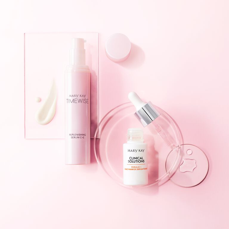 Mary Kay Timewise Replenishing Serum and Clinical Solutions brightener on pink background.
