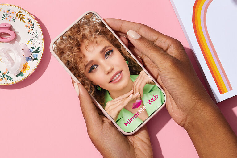 Hands holding a phone opening the MirrorMe Web experience