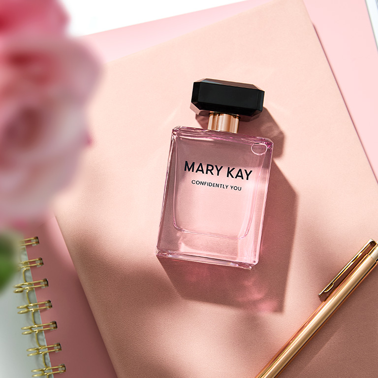 Confidently You Eau de Parfum bottle on a pink notepad