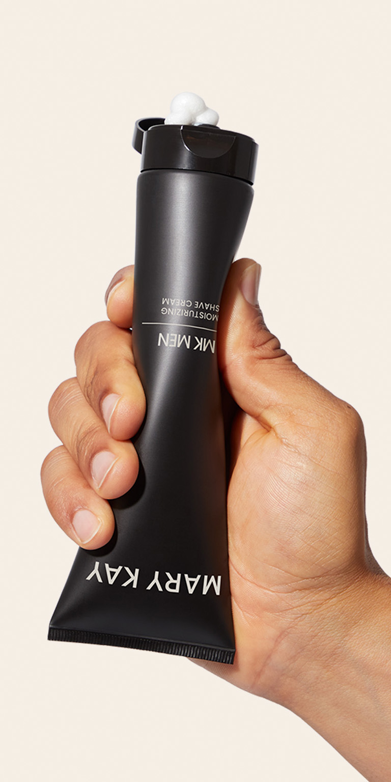 Hand squeezing tube of Mary Kay MKMen Shave Cream